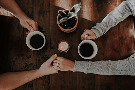 Pareja disfrutando de una taza de café mientras se toman de la mano